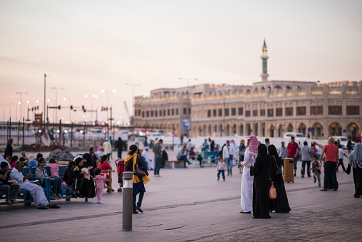 Doha,Qatar - March 05, 2019 : A man and a woman are walking in traditional attire on the street of old bazaar market Souk Waqif.