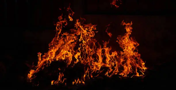 Photo of Panorama Fire flames on black background.global warming concept.Abstract background  sparks, dark glitter, light particles, light. Bonfire in motion blur.