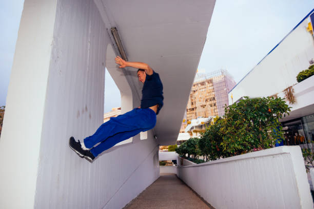 istock Young parkour man jumping from one to another wall while doing some tricks. 1385122497