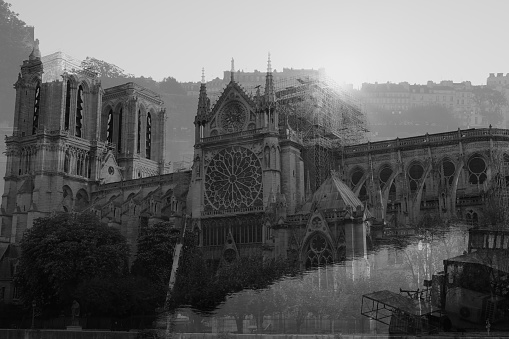 Double exposure of the Cathedral Notre Dame one week after the great fire. Sun rises through the cathedral.