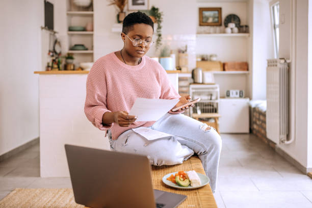 istock Young beautiful woman going over finances at home 1385131381