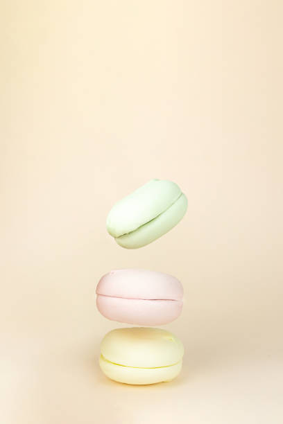 Delicious sweet puffy Colorful marshmallows flying on pastel beige background. Sweet break concept