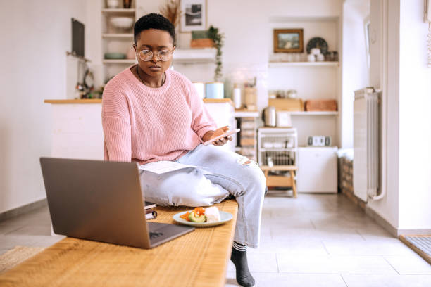 istock Young beautiful woman going over finances at home 1385131968