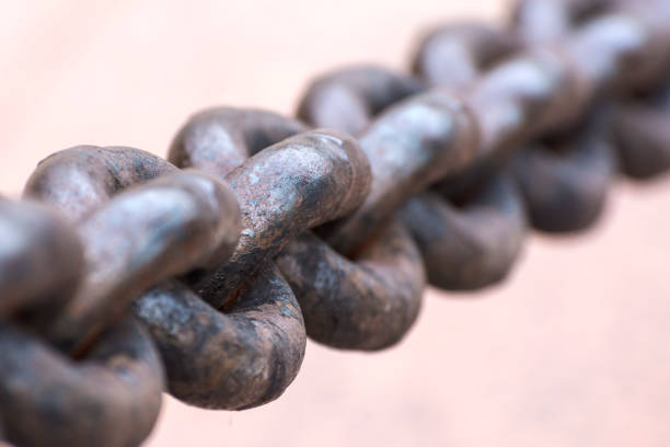 Old rusty anchor chain in the port. Iron chain links defocused diagonally. Blurred background. Old rusty anchor chain in the port. Iron chain links defocused diagonally. Macrophotography, close up. Blurred background. anchor chain stock pictures, royalty-free photos & images