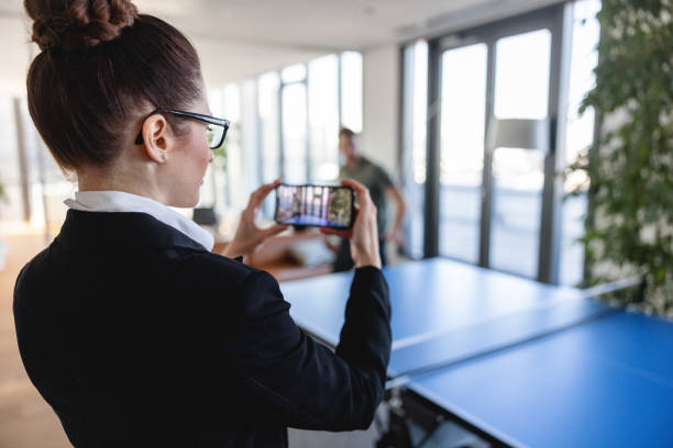 istock Caucasian Office Worker Recording An Intense Table Tennis Match 1385138538