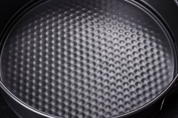 istock Round cake pan, tray or mould on a black concrete background 1385139873