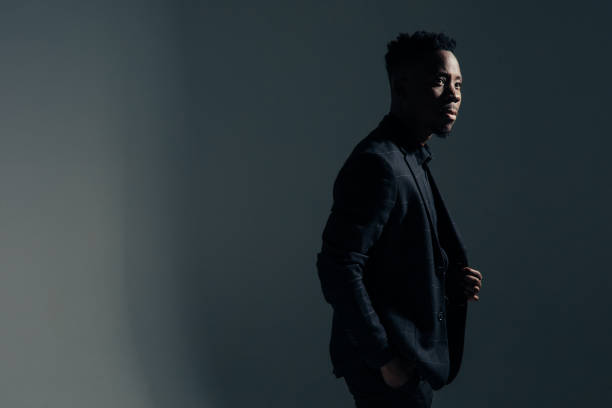 istock Young african man stands against gray background. 1385150749