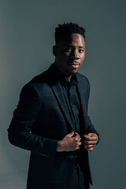 istock Young african man stands against gray background. 1385151163