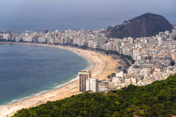 вид с воздуха на пляж копакабана с его зданиями, морем и ландшафтом. огромные холмы по всей длине. необъятность города рио-де-жанейро, бразил - flamengo стоковые фото и изображения