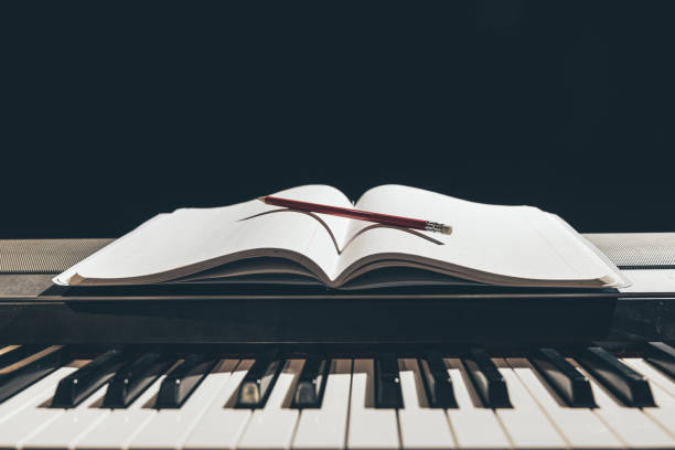 istock Open notepad on piano keys in the dark, copy space. 1385152612