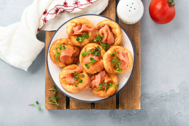 istock Yorkshire pudding. Traditional English Yorkshire pudding with salmon and radish microgreens side dish on white plate and light grey background table. Top view. 1385152692