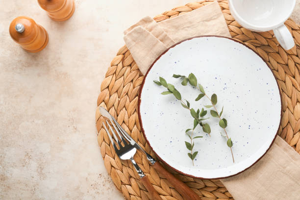 istock Vintage zero waste silverware. Rustic vintage set of white plate, wooden spoon and fork on napkin for dishes from water hyacinth on light gray concrete background. Empty dishes. Top view. Mock up. 1385152712
