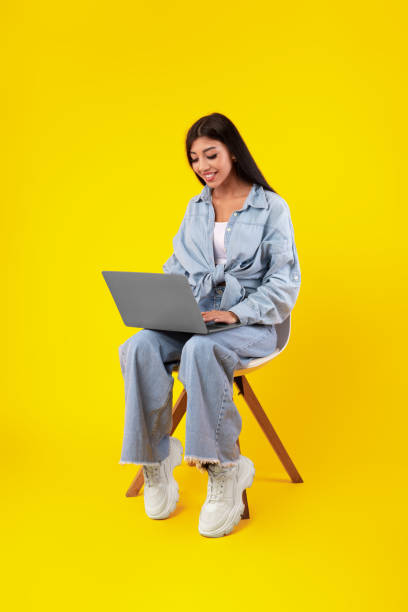istock Cheerful young woman using laptop at studio 1385153020