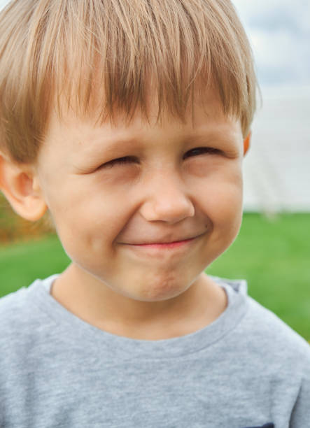 Happy child little boy 4 years old smiling outdoors, looking at camera