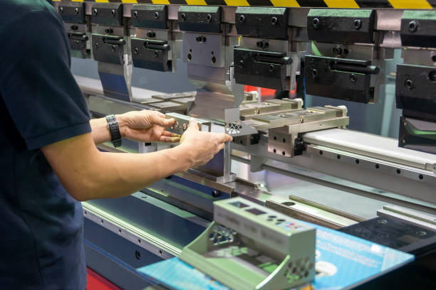 istock The hand of technician operator working with hydraulic press brake bending machine. 1385153890