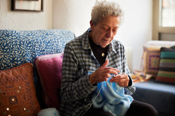 istock An old woman is crocheting at home. 1385153923