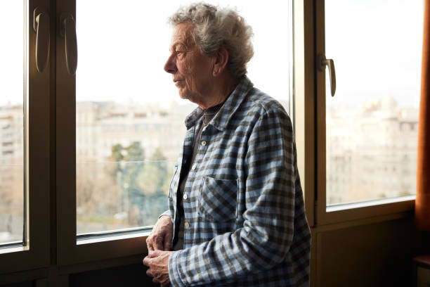 istock One senior woman looking out the window. 1385154022