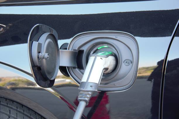 istock Power supply connect to electric vehicle for battery charging. Transport loading technology industry, which are the futuristic of the automobile. EV Fuel Plug in Hybrid Car 1385165296