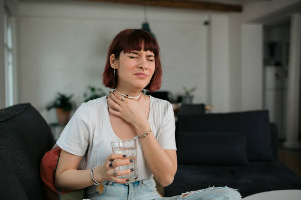 young caucasian woman feeling sick at home - boğaz ağrısı stok fotoğraflar ve resimler