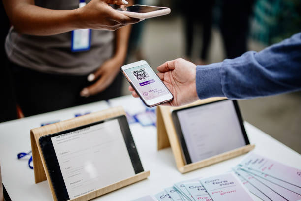 kuvapankkikuvat ja rojaltivapaat kuvat aiheesta konferenssin henkilökunnan jäsen skannaa qr-koodin osallistujalta saapuessaan sisäänkirjautumissivustolle - ilmoittautumislomake