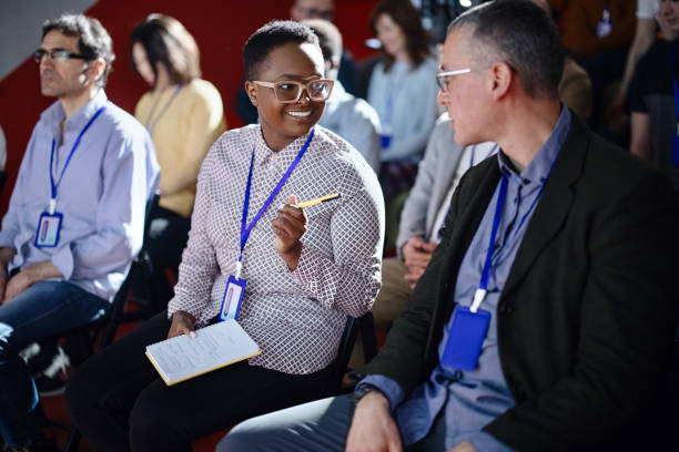 istock Businesspeople laughing and talking in between breaks during  conference event 1385168525