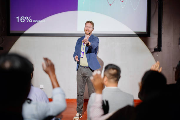 istock Business people raising hands to ask questions during a seminar. 1385168545