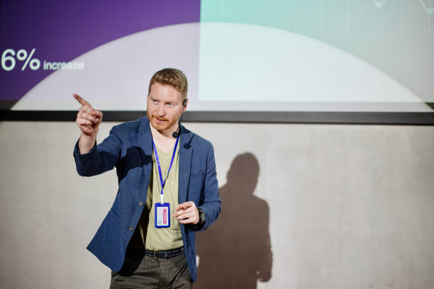 istock Male conference speaker points to audience for questions. 1385168679