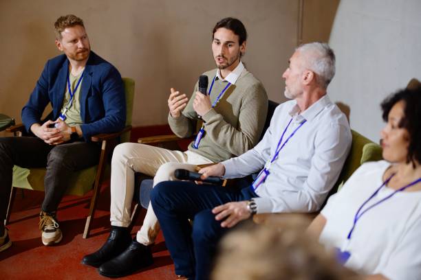 istock Young panelist sharing his motivational  story to the audience 1385168772