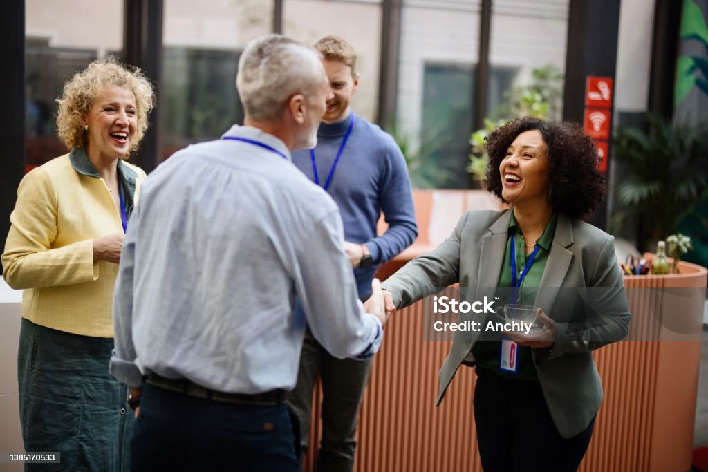 Business people greet each other during a coffee break at a conference Conference speakers handshaking after presentation at the convention center Networking Stock Photo
