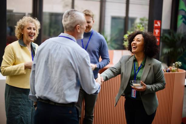 Business people greet each other during a coffee break at a conference Conference speakers handshaking after presentation at the convention center event stock pictures, royalty-free photos & images