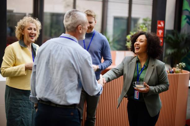 Business people greet each other during a coffee break at a conference Conference speakers handshaking after presentation at the convention center conference centre stock pictures, royalty-free photos & images