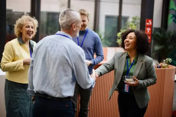 Photo of Business people greet each other during a coffee break at a conference