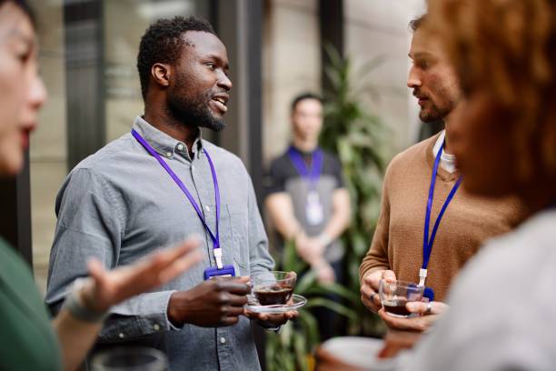 istock Entrepreneurs drinking black coffee while standing with colleagues in convention center 1385170543