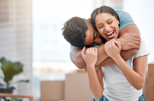 foto de un joven sintiéndose juguetón y abrazando a su novia en su nuevo hogar - parejas abrazadas fotografías e imágenes de stock