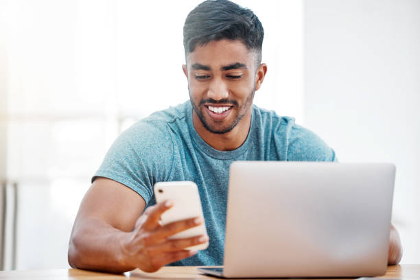 istock Shot of a handsome young man sitting alone at home and using technology 1385170849
