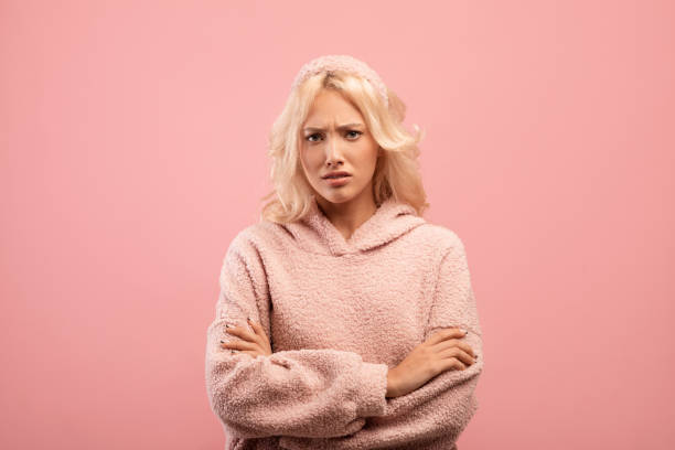 senhora ofendida de pé com os braços cruzados e olhando para a câmera, mulher mal-humorada sentindo raiva e descontente - women sadness isolated human face - fotografias e filmes do acervo