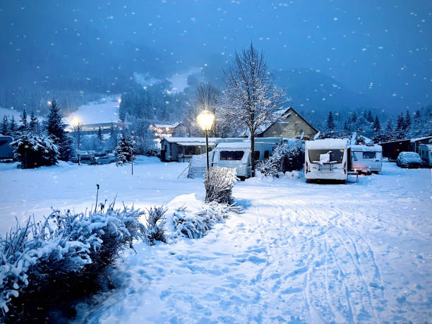 Winter camping in the snow on a campsite in Austria with snow falling at night