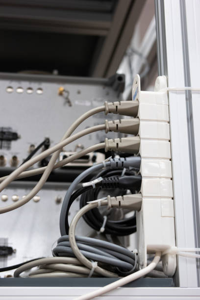 istock Full power outlet extension cord. Plugged in sockets, maximum capacity, overload danger. Set in industrial building, no people, shallow depth of field 1385175169