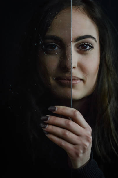 istock Aging Process - Beautiful long haired young woman holding a glass plate covered with droplets in front of her face, imperfections that come with time 1385175492
