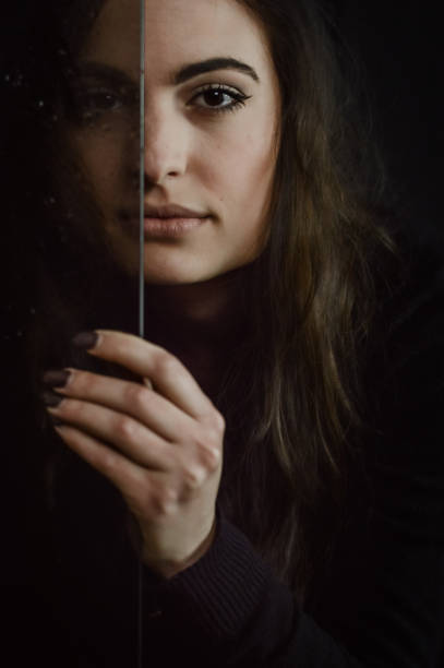 istock Aging Process - Beautiful long haired young woman holding a glass plate covered with droplets in front of her face, imperfections that come with time 1385176151
