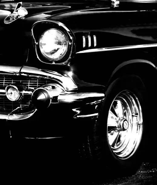 front view close of 1957 hot rod, black and white, no people, view from front and side, chrome wheel and bumper, chrome accents