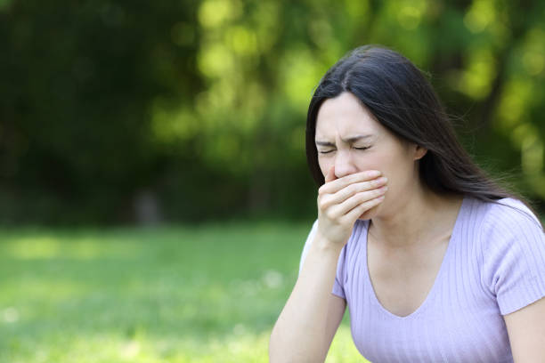 istock Asian woman coughing in a park 1385177991
