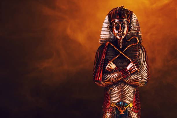 istock Egyptian pharaoh figurine in orange smoke on a black background. 1385180570