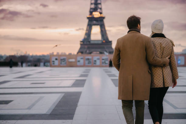 istock Romantic couple hugging each other while walking on Parvis des Droits de l'Homme in front of Eiffel Tower 1385180857