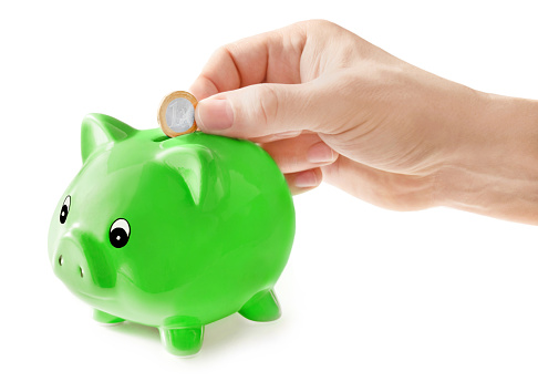 Finances with male hand feeding piggy bank and Euro coin isolated against white background
