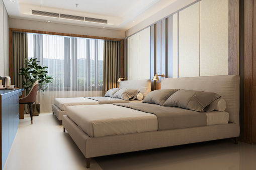 Side View Of Luxury Hotel Room With Two Beds, Chair And Potted Plant