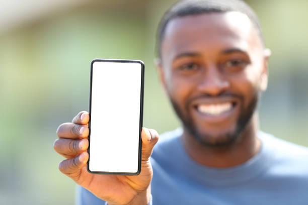 istock Happy man with black skin showing blank phone screen 1385186516