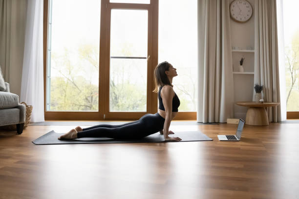 istock Slender woman perform Upward Facing Dog practicing yoga at home 1385188214