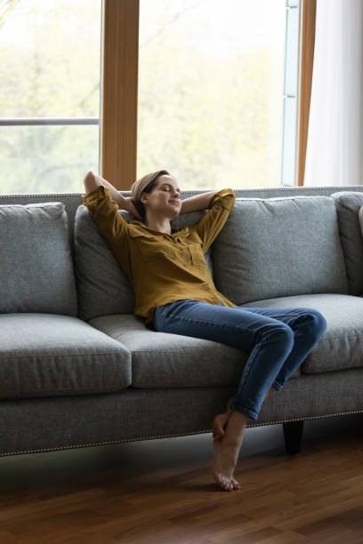 istock Vertical view serene woman relax on sofa with eyes closed 1385188295