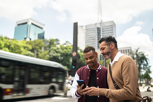 Gay couple using the mobile phone in the street